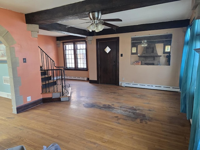 entryway with a baseboard heating unit, stairs, beamed ceiling, ceiling fan, and wood finished floors
