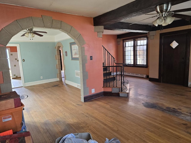 foyer entrance featuring baseboards, a ceiling fan, stairs, a baseboard radiator, and wood finished floors