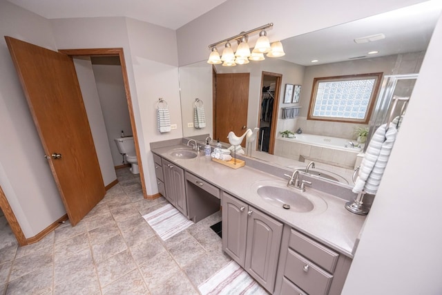 bathroom with a sink, toilet, and a garden tub