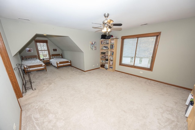 unfurnished bedroom featuring light colored carpet, a ceiling fan, visible vents, lofted ceiling, and baseboards