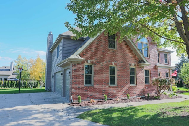 view of home's exterior featuring brick siding, driveway, a chimney, and a lawn