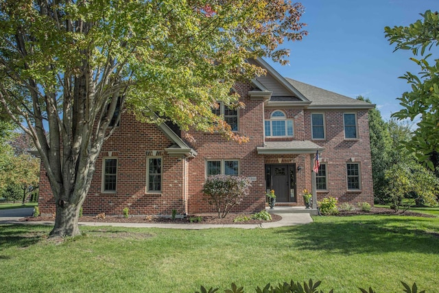 view of front of house featuring a front yard and brick siding