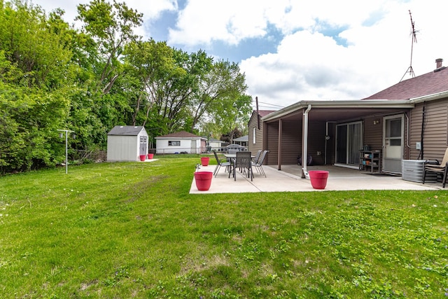 view of yard with a storage unit, a patio area, and an outbuilding