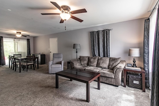 living room with a ceiling fan and light colored carpet