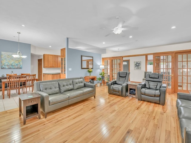 living area with recessed lighting, ceiling fan with notable chandelier, light wood finished floors, and a healthy amount of sunlight