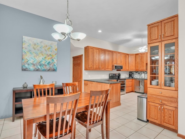 kitchen featuring light tile patterned flooring, dark countertops, stainless steel appliances, decorative light fixtures, and recessed lighting