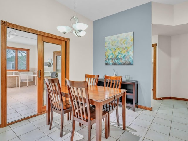 dining space featuring baseboards, a chandelier, and light tile patterned floors