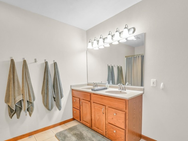 bathroom featuring a sink, tile patterned floors, baseboards, and double vanity