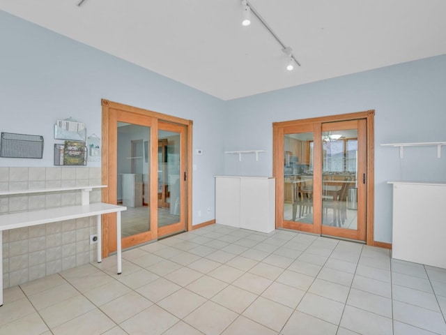 empty room with tile patterned floors, track lighting, and baseboards