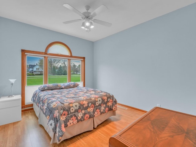 bedroom with baseboards, ceiling fan, and light wood finished floors