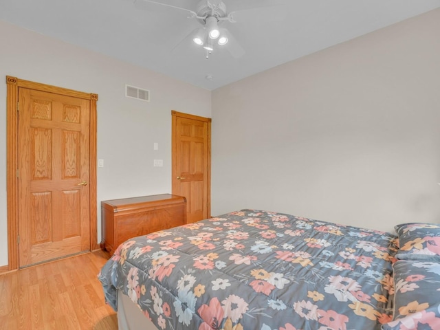 bedroom featuring ceiling fan, visible vents, and light wood-style flooring