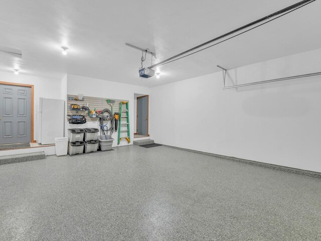 garage featuring a garage door opener and freestanding refrigerator