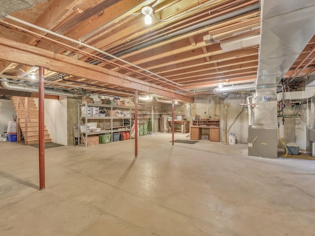 unfinished below grade area featuring stairs and heating unit