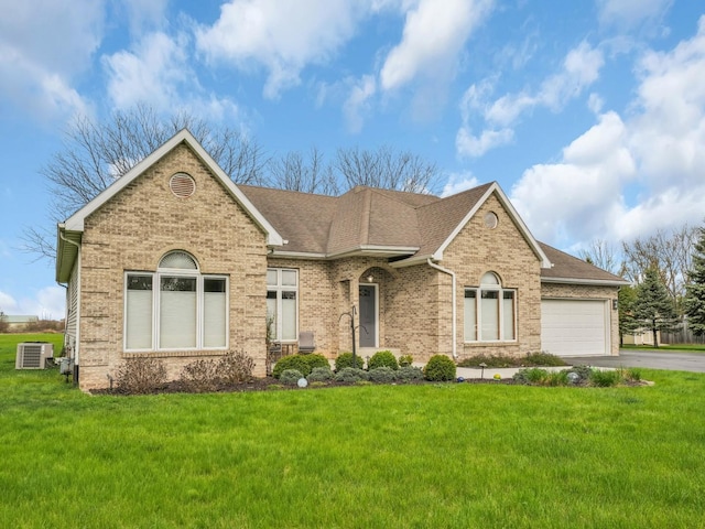 ranch-style home featuring brick siding, driveway, a front yard, and cooling unit