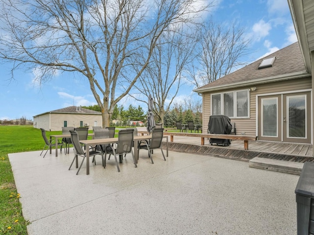 view of patio with area for grilling, a deck, and outdoor dining space