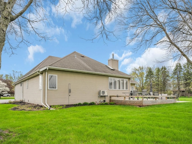 back of property featuring a lawn, ac unit, a chimney, and a shingled roof