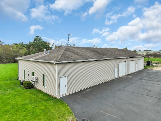 view of property exterior featuring a lawn, a shingled roof, and a garage