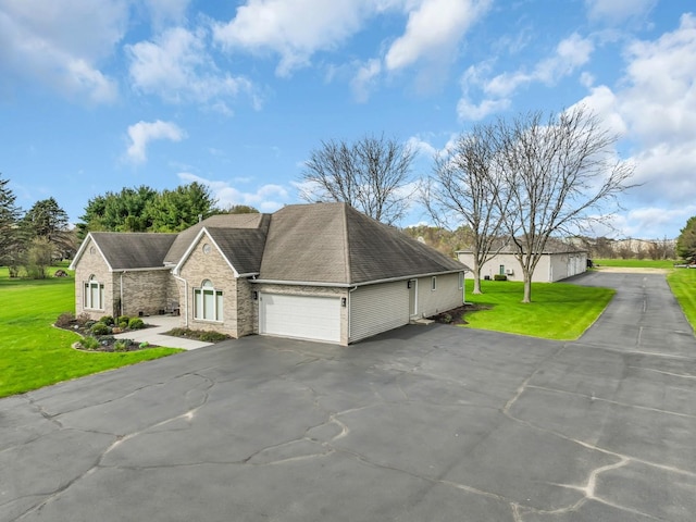 view of front of house featuring roof with shingles, brick siding, aphalt driveway, an attached garage, and a front lawn