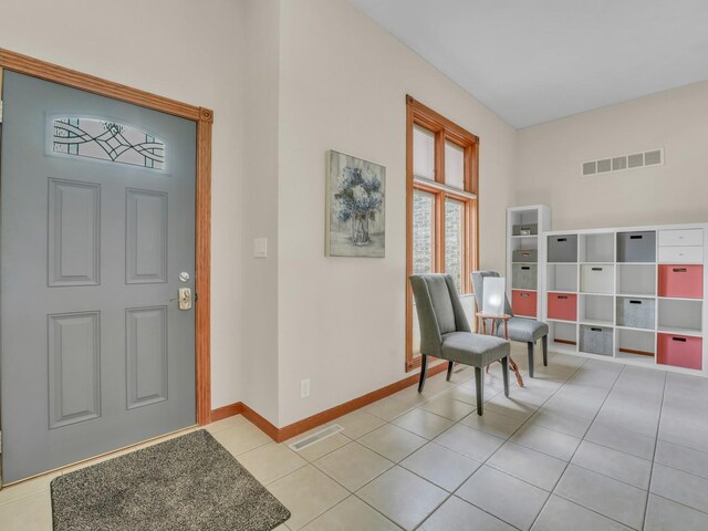 entrance foyer featuring baseboards, visible vents, and light tile patterned floors