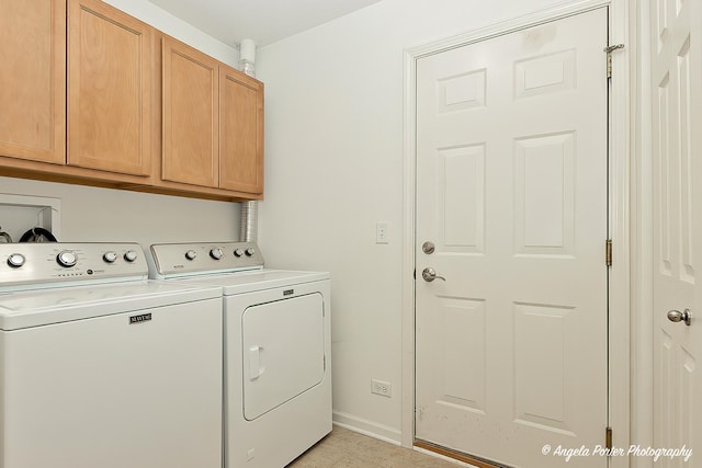 clothes washing area with washer and dryer, baseboards, and cabinet space