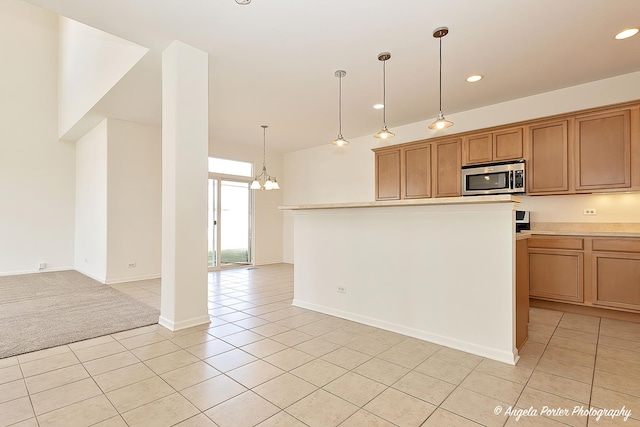 kitchen featuring recessed lighting, light tile patterned flooring, stainless steel microwave, light countertops, and a notable chandelier