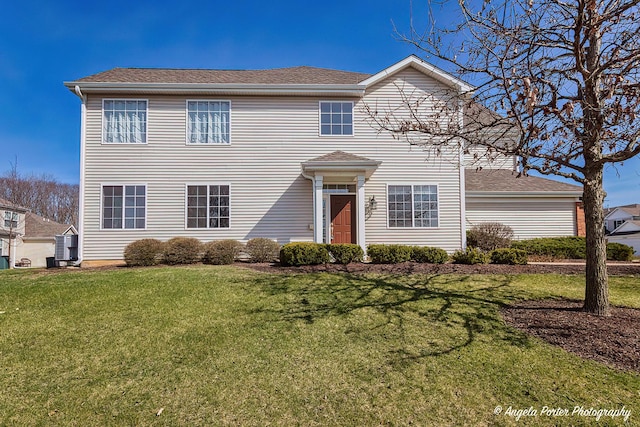traditional home with a front lawn and a shingled roof