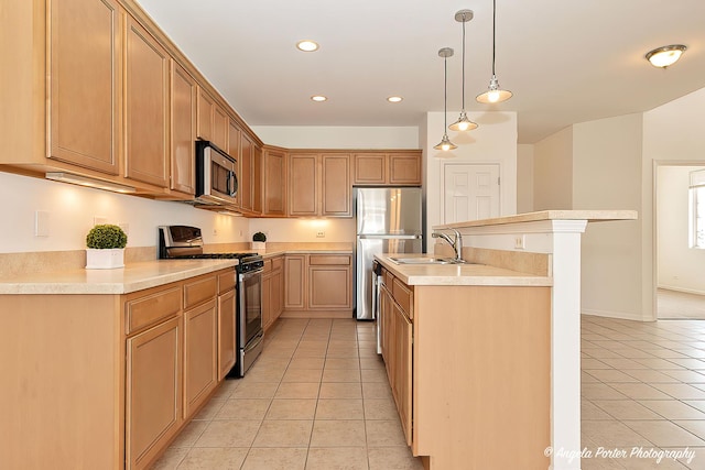 kitchen with light tile patterned floors, a sink, light countertops, appliances with stainless steel finishes, and a center island with sink
