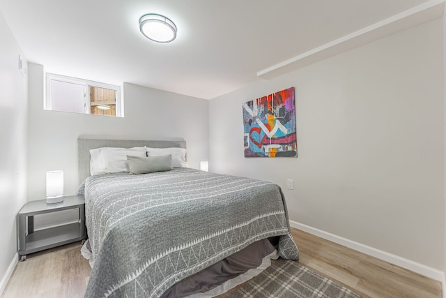 bedroom featuring baseboards and wood finished floors