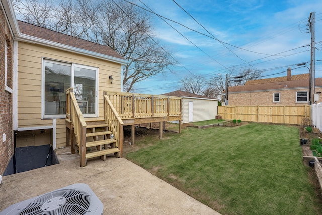 view of yard with a patio, central AC, a wooden deck, an outbuilding, and fence