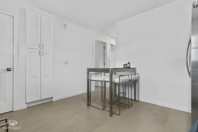 dining space featuring baseboards and wood finished floors
