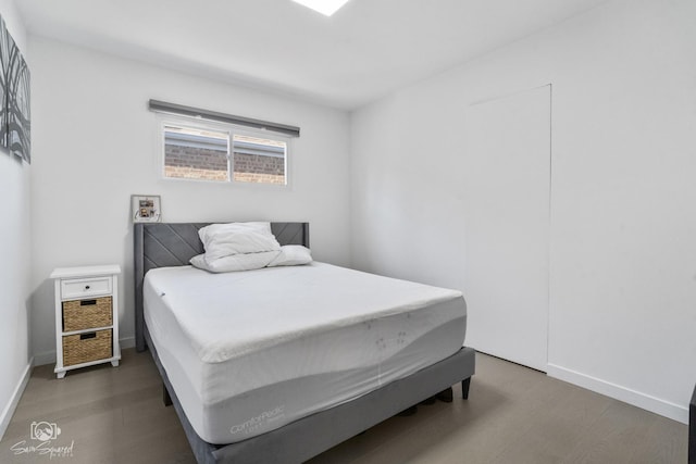 bedroom with baseboards and wood finished floors