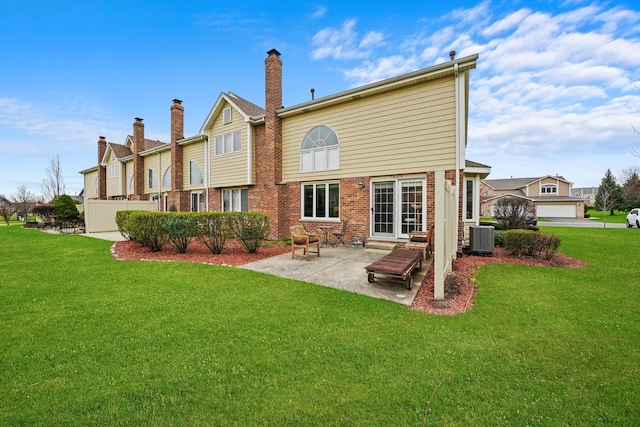 rear view of property with a patio area, brick siding, cooling unit, and a lawn
