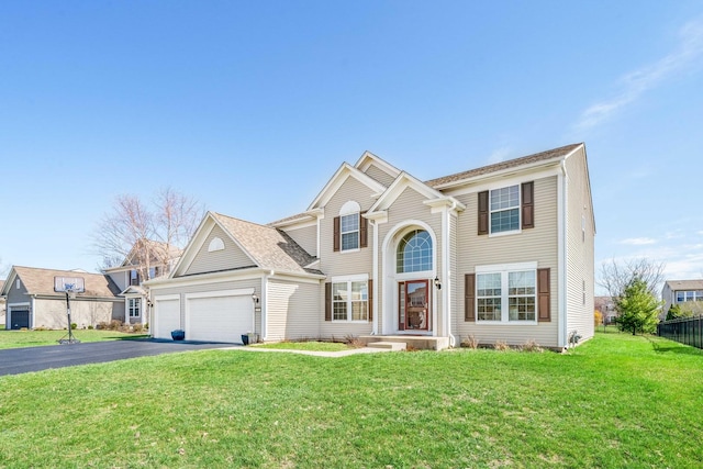 traditional-style home with driveway, an attached garage, and a front lawn
