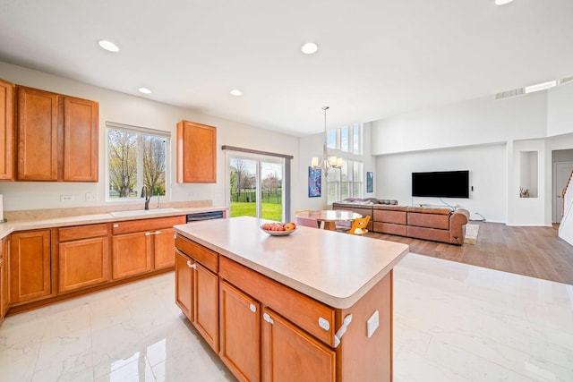 kitchen featuring a sink, a center island, light countertops, and marble finish floor