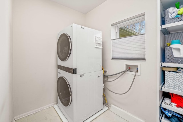 laundry room featuring stacked washing maching and dryer, laundry area, and baseboards
