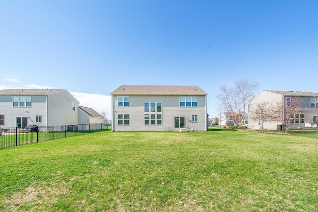 back of property featuring fence and a lawn