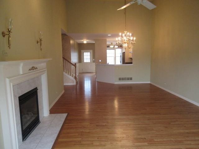 2844 Waterfront Ave, Algonquin, IL 60102 - unfurnished living room featuring light wood-type flooring, baseboards, a fireplace, stairway, and ceiling fan with notable chandelier