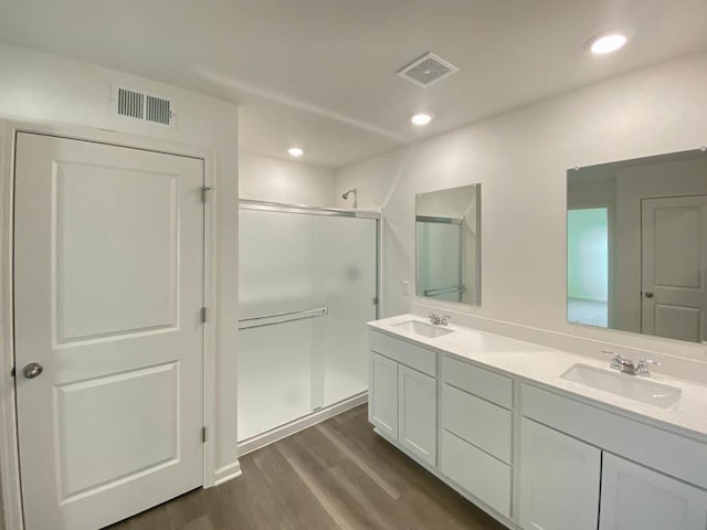 2011 Winterberry Trl, Wonder Lake, IL 60097 - full bathroom featuring a stall shower, wood finished floors, a sink, and visible vents