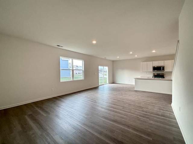 2011 Winterberry Trl, Wonder Lake, IL 60097 - unfurnished living room featuring dark wood-type flooring, baseboards, visible vents, and recessed lighting