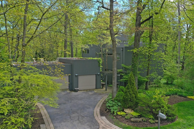 view of property's community with a garage and aphalt driveway