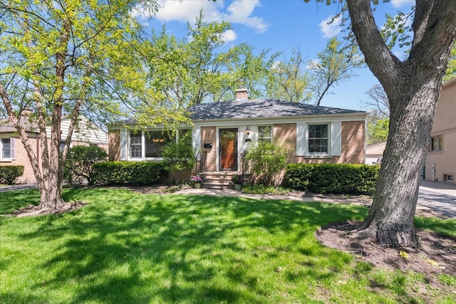 1945 Bosworth Ln, Northfield, IL 60093 - view of front facade with brick siding, a front yard, and a chimney