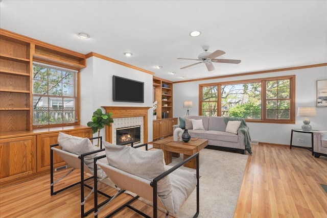 1945 Bosworth Ln, Northfield, IL 60093 - living room with crown molding, a glass covered fireplace, ceiling fan, light wood-type flooring, and baseboards