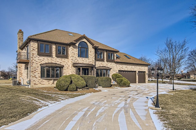 2658 E Royal Ridge Dr, Crete, IL 60417 - view of front of home with a tiled roof, a garage, brick siding, a chimney, and concrete driveway