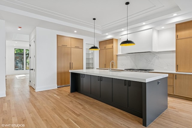 3846 N Bell Ave, Chicago, IL 60618 - kitchen featuring a tray ceiling, recessed lighting, light countertops, decorative backsplash, and a large island with sink