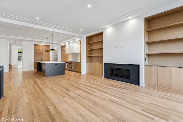 3846 N Bell Ave, Chicago, IL 60618 - unfurnished living room with a fireplace, light wood finished floors, built in features, and recessed lighting