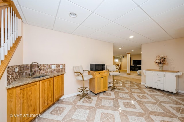 1641 Foster Cir, Algonquin, IL 60102 - kitchen with black microwave, a sink, light stone countertops, baseboards, and backsplash