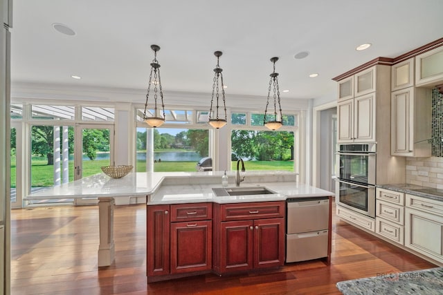 2426 Lexington Dr, Long Grove, IL 60047 - kitchen featuring appliances with stainless steel finishes, dark brown cabinets, dark wood-style floors, pendant lighting, and decorative backsplash