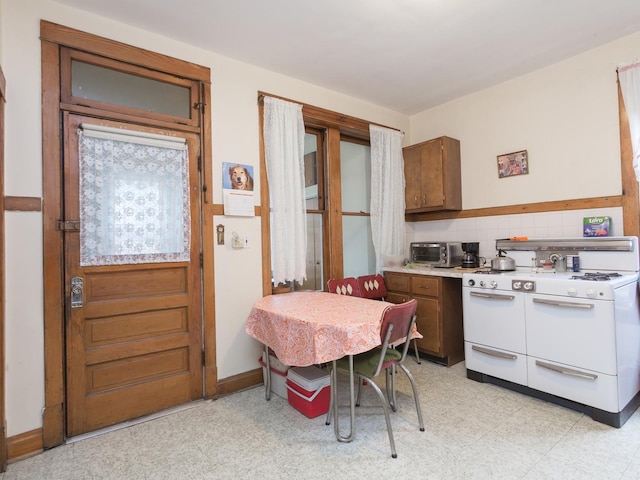 4249 W Melrose St, Chicago, IL 60641 - kitchen featuring light floors, light countertops, decorative backsplash, baseboards, and range with two ovens