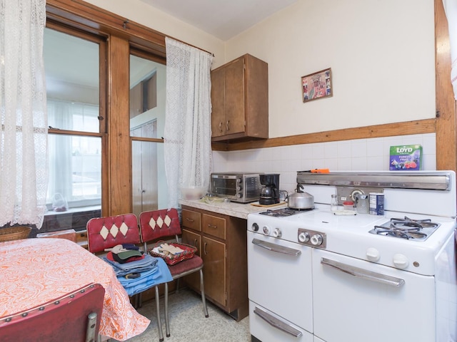 4249 W Melrose St, Chicago, IL 60641 - kitchen featuring tasteful backsplash, light countertops, white gas range, and a toaster