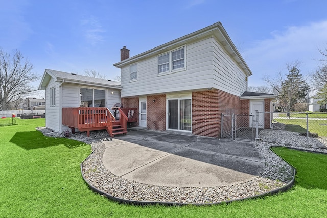 back of property with a gate, fence, brick siding, a lawn, and a deck